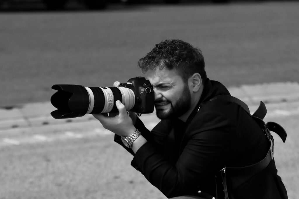 Black and white image of a photographer capturing a scene in Naples, Italy.